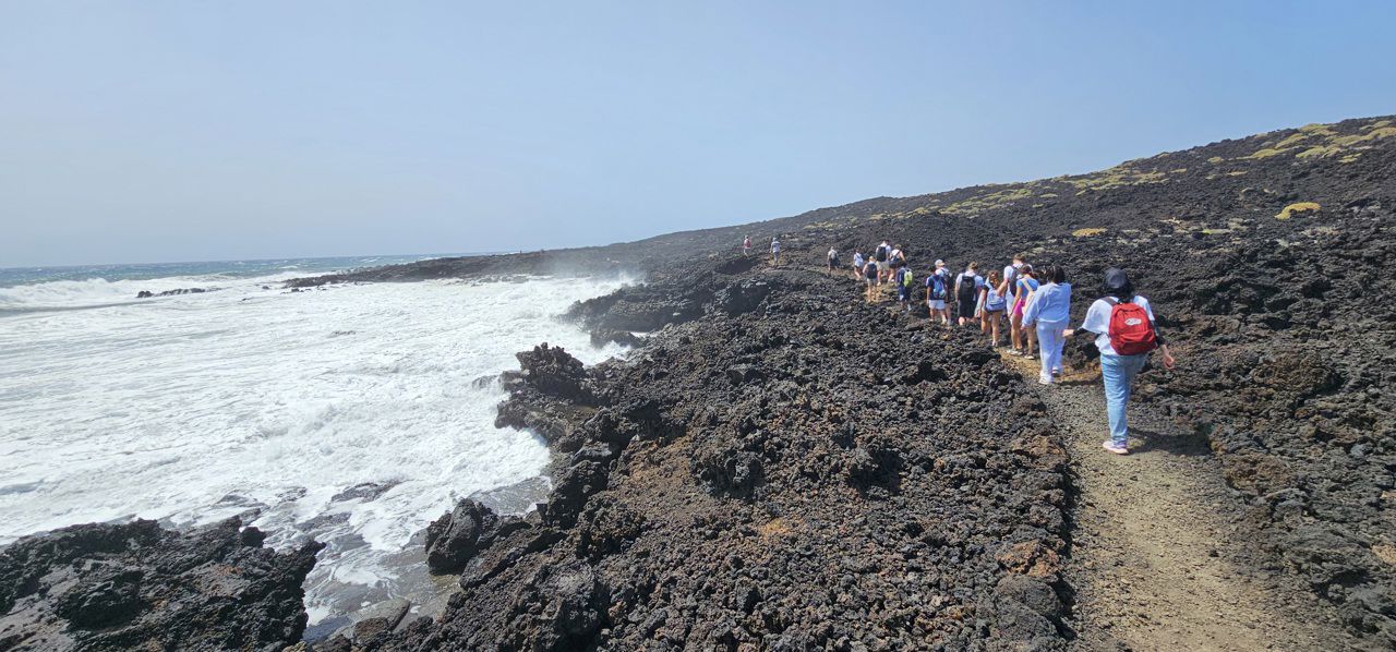 Foto av elever på vei inn i vulkansk landskap